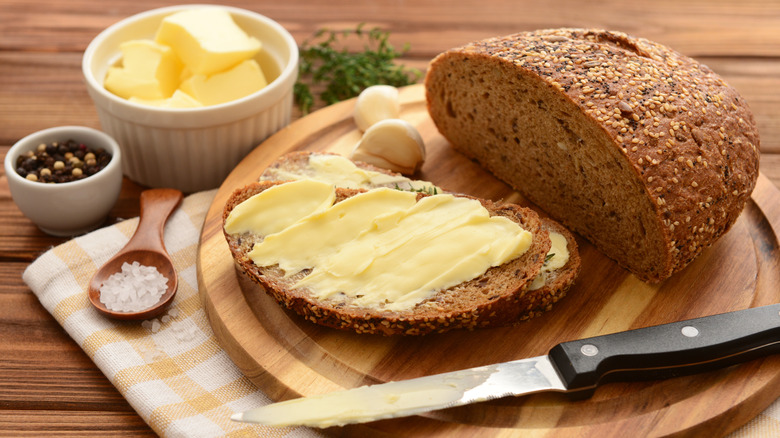 Sliced bread and butter on a wooden board