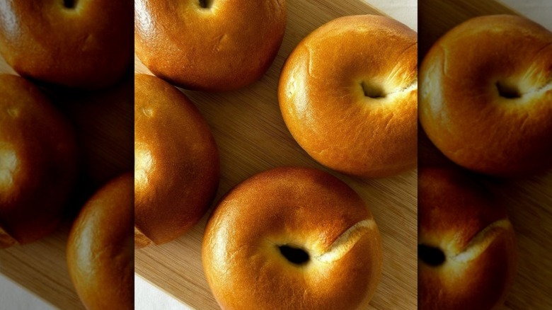 freshly made plain bagels sit on a cutting board