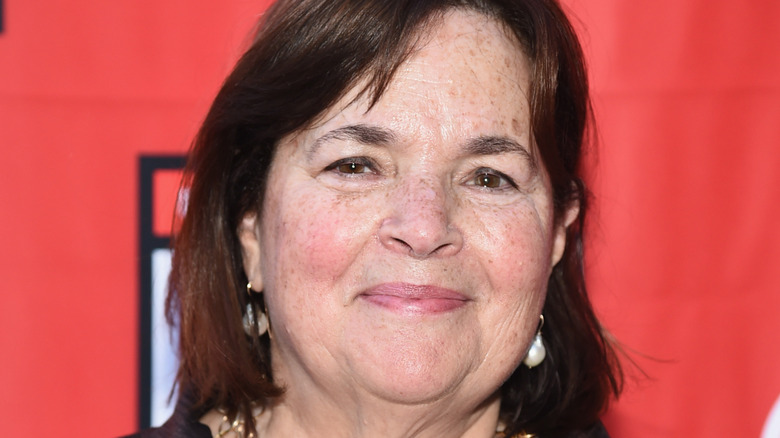 A close up photo of Ina Garten with a red background