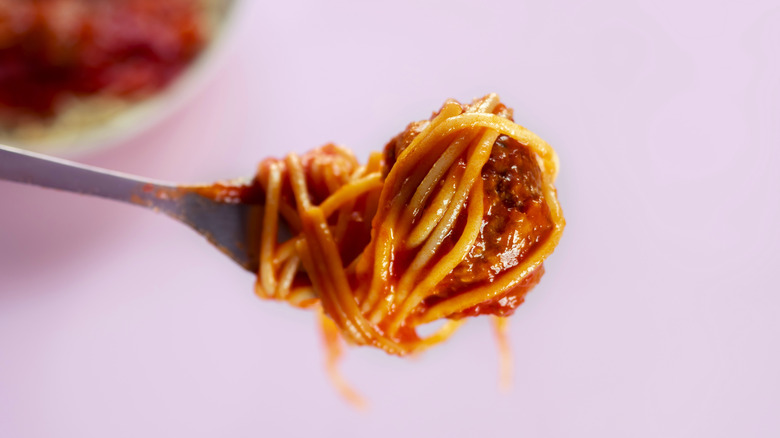 Close-up of spaghetti wrapped around meatballs on a fork