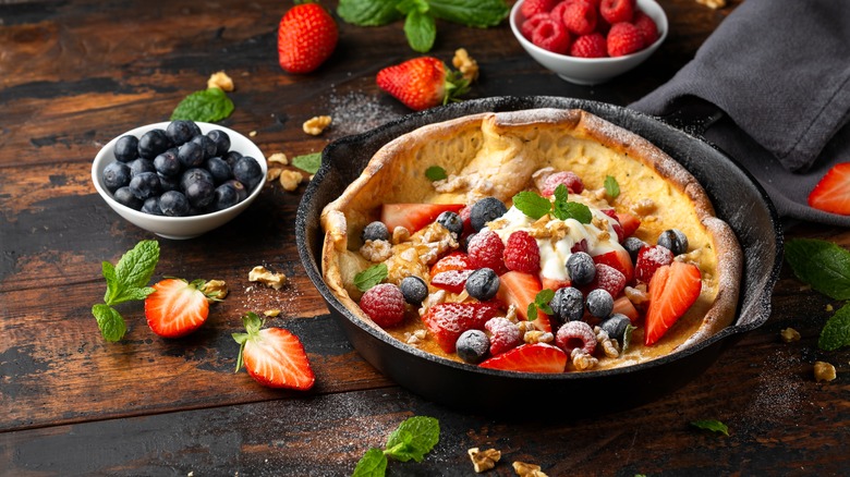 A Dutch baby pancake with berries in a cast iron pan