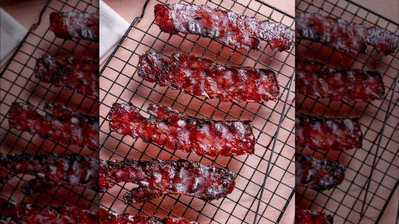 Strips of caramelized bacon on a rack.