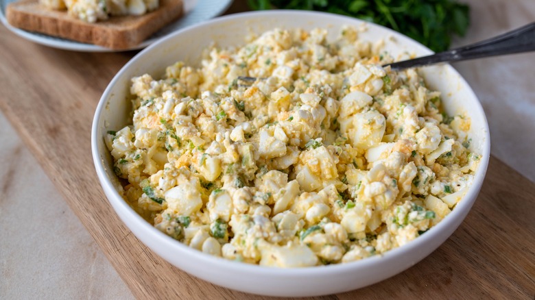 Egg salad in white bowl with spoon