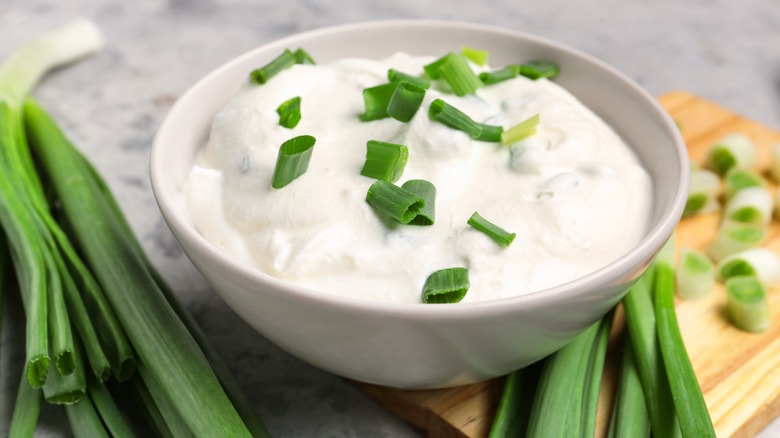 Sour cream in white ramekin with scallions