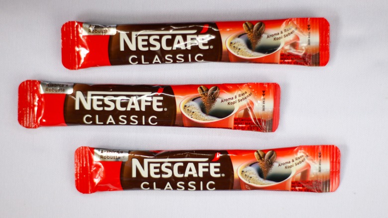 Three packets of Nescafe instant coffee