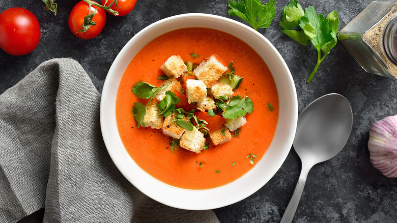 Bowl of tomato soup with herbs and croutons