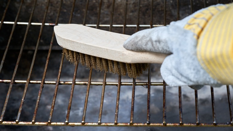 cleaning a grill with a brush