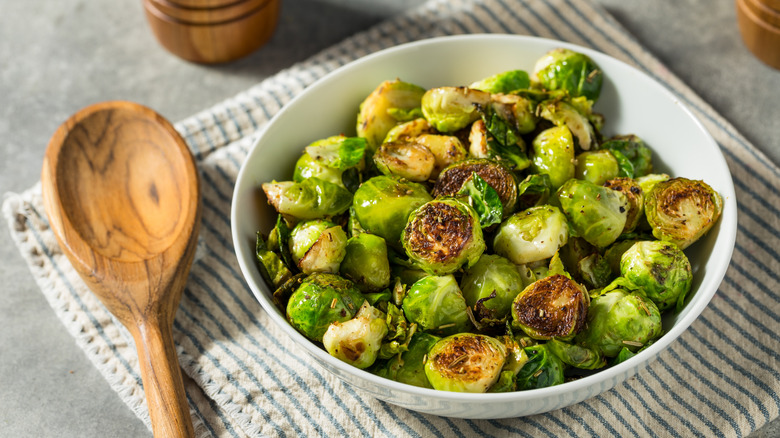 Roasted Brussel Sprouts in a bowl with a wooden spoon