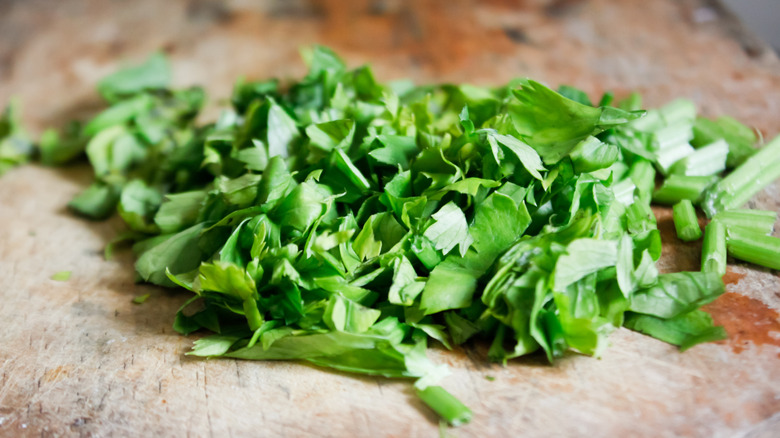 Sliced ​​green celery leaves on a cutting board