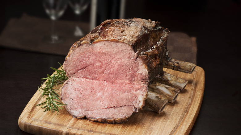 Juicy bone-in prime rib on a wooden cutting board