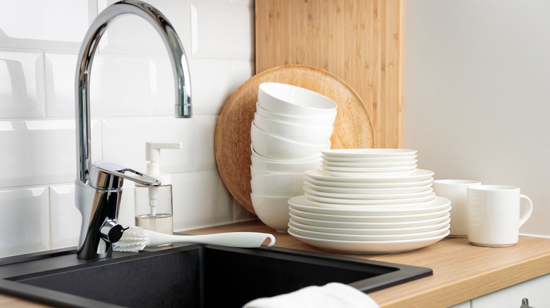 A few stacks of clean dishes next to the sink