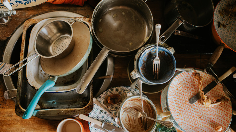 A sink full of dirty dishes the morning after a dinner party