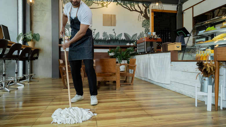 A person mopping the floor at a restaurant