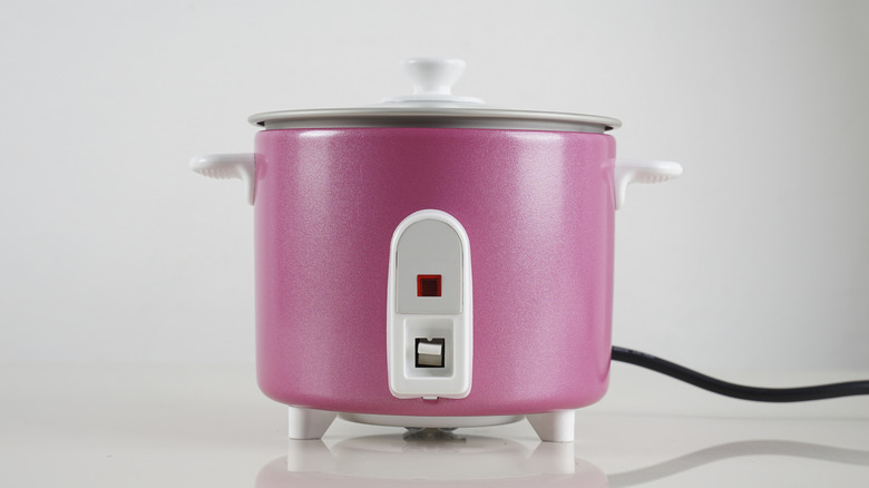 a pink rice cooker on a white background