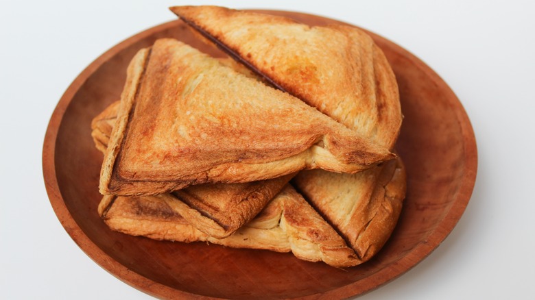 pieces of toast resting on a wooden plate