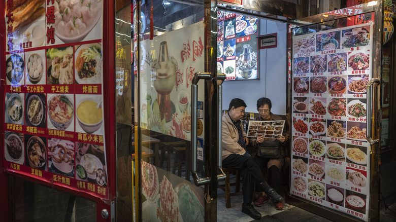 diners examine chinese restaurant menu with pictures