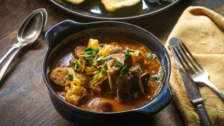 A bowl of bigos, or a Polish hunter's stew sitting on a table.