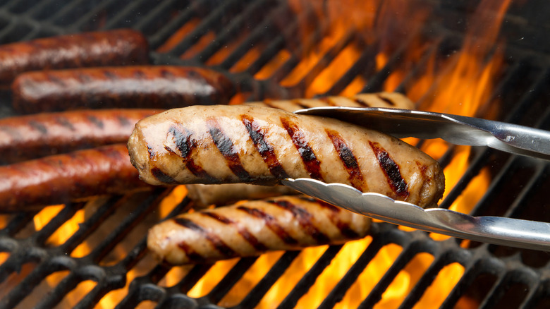 Different types of German sausages cooking on a hot grill