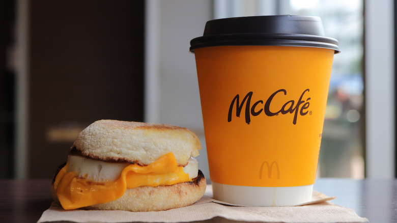 An egg McMuffin and a McDonald's coffee cup are shown together