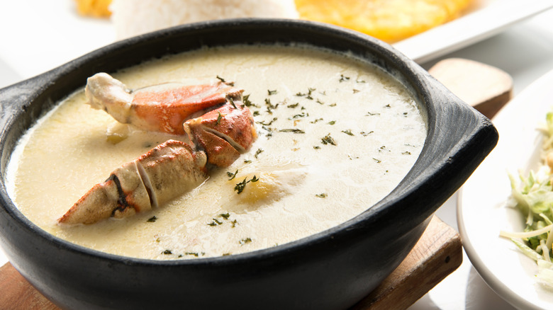 A bowl of soup with a crab leg on top