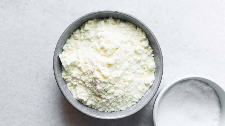 An overhead view of powdered milk in a grey bowl