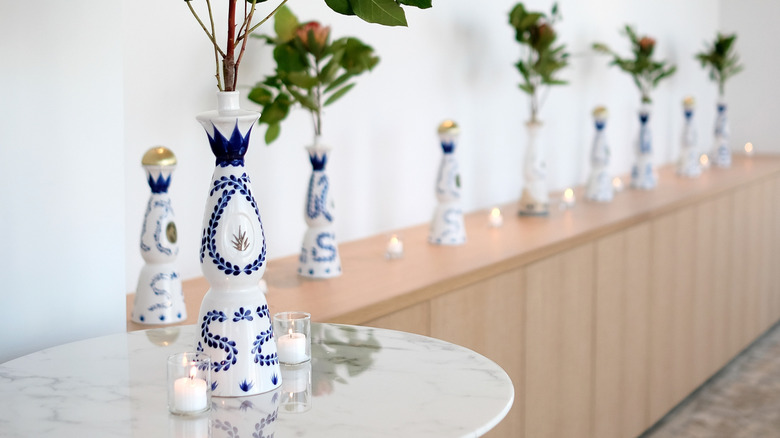 Bottles of Clase Azul on display in a gallery setting. Some are being used as vases