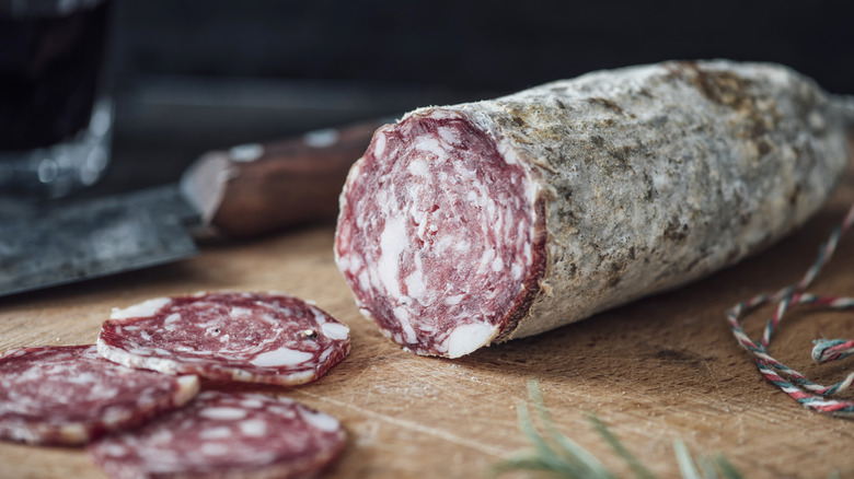 Sliced salami on wooden board