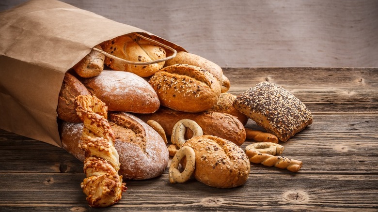 Brown bag filled with assorted breads falling out