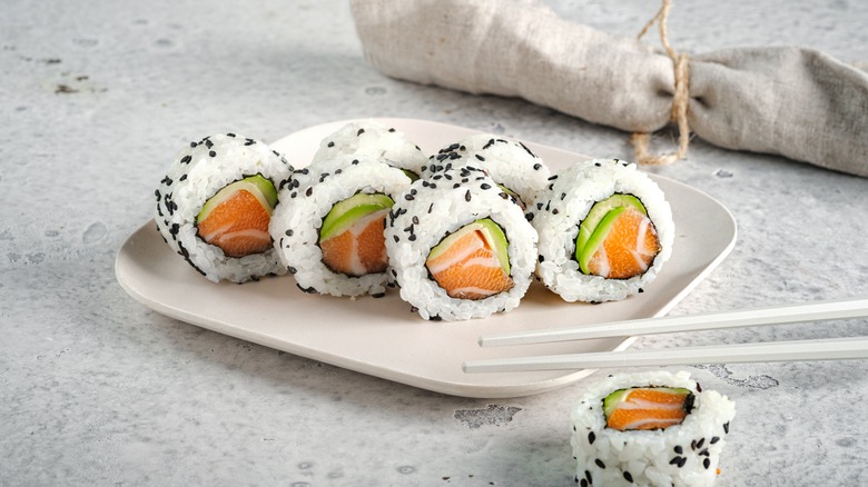 Salmon sushi roll sprinkled with black sesame seeds