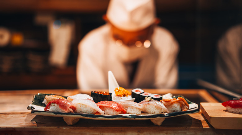 A sushi chef plating sushi