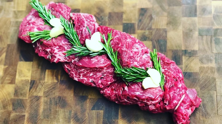 braided steak with herb and garlic garnish