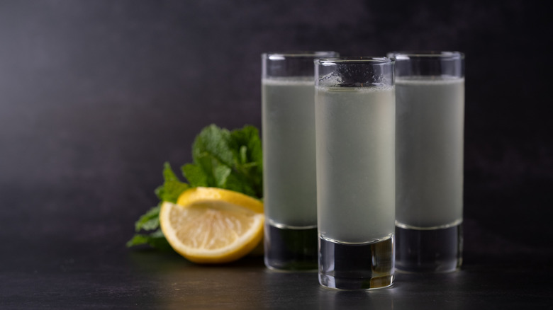 Three full shots with lemon and mint in the background