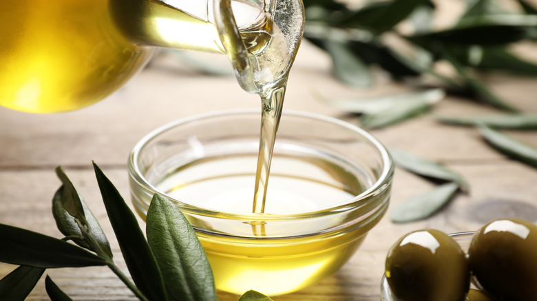 Pouring olive oil into a small glass bowl