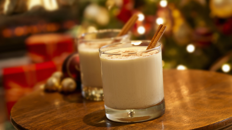 Two glasses of eggnog on festively decorated table