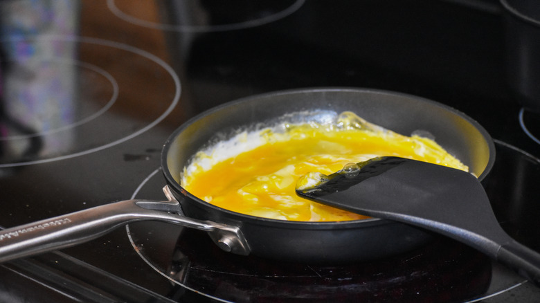 cooking eggs with black plastic spatula