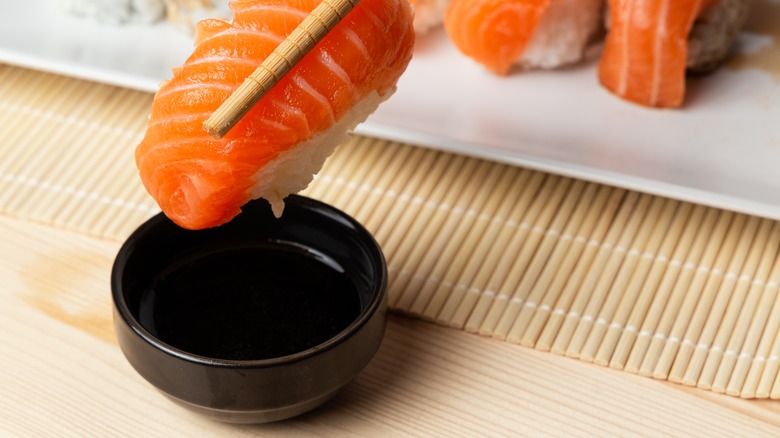 sushi being dipped soy sauce