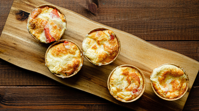 Five soufflés laid out on a wooden board