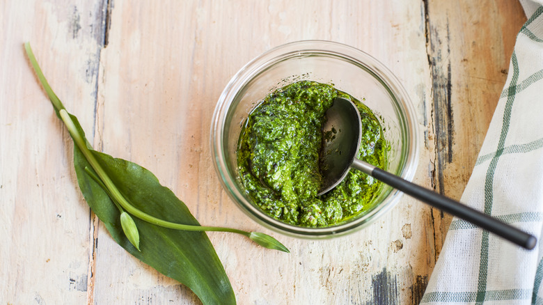 a bowl of pesto with a spoon in it