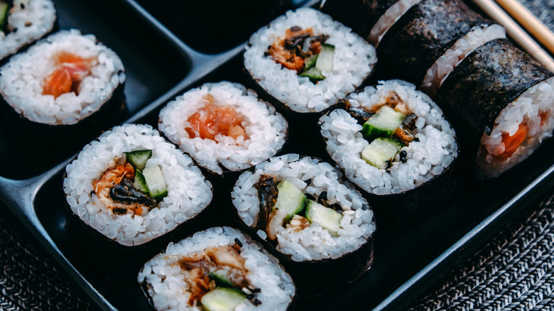 sushi rolls in black tray