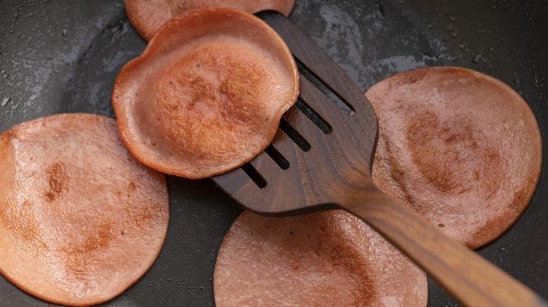 Bologna slices being fried