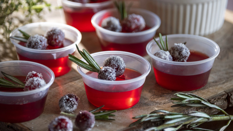 Red Jell-O shots with frosted cranberries and rosemary.