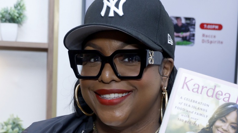 Kardea Brown holding a copy of her cookbook.