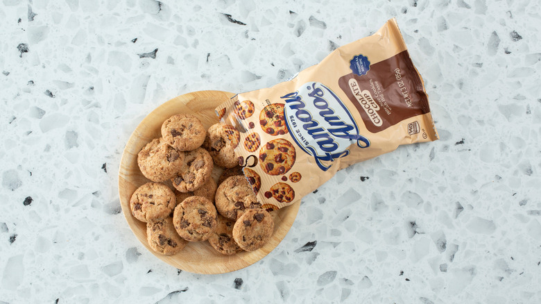 Famous Amos chocolate chip cookies spilling out of bag onto plate