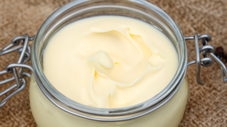 A jar of beef tallow which is slightly firmer and more yellow than lard