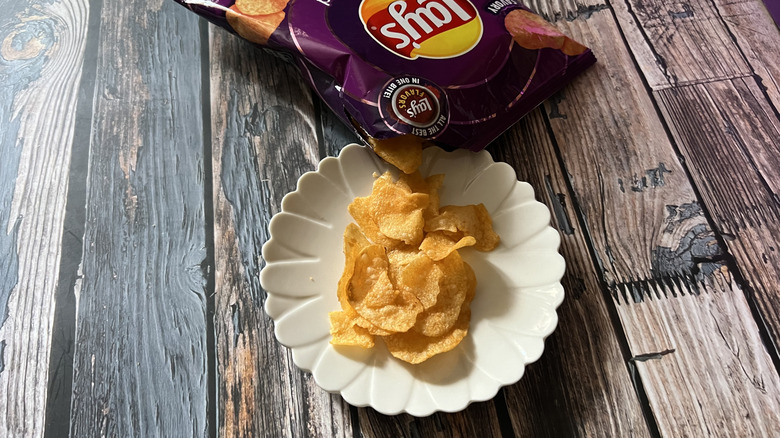 an open bag of Lay's All Dressed spills onto a plate