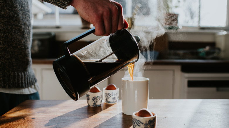 Man pouring a hot cup of coffee