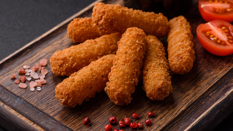 Mozzarella sticks on brown cutting board