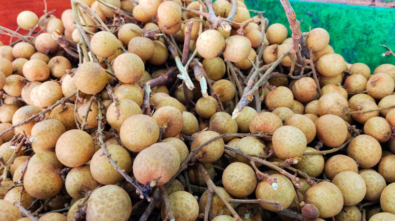 a pile of longan fruits still on their stems