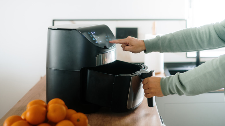 person using air fryer