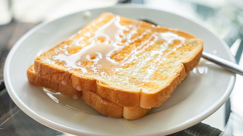 Toast with sweetened condensed milk on a white plate